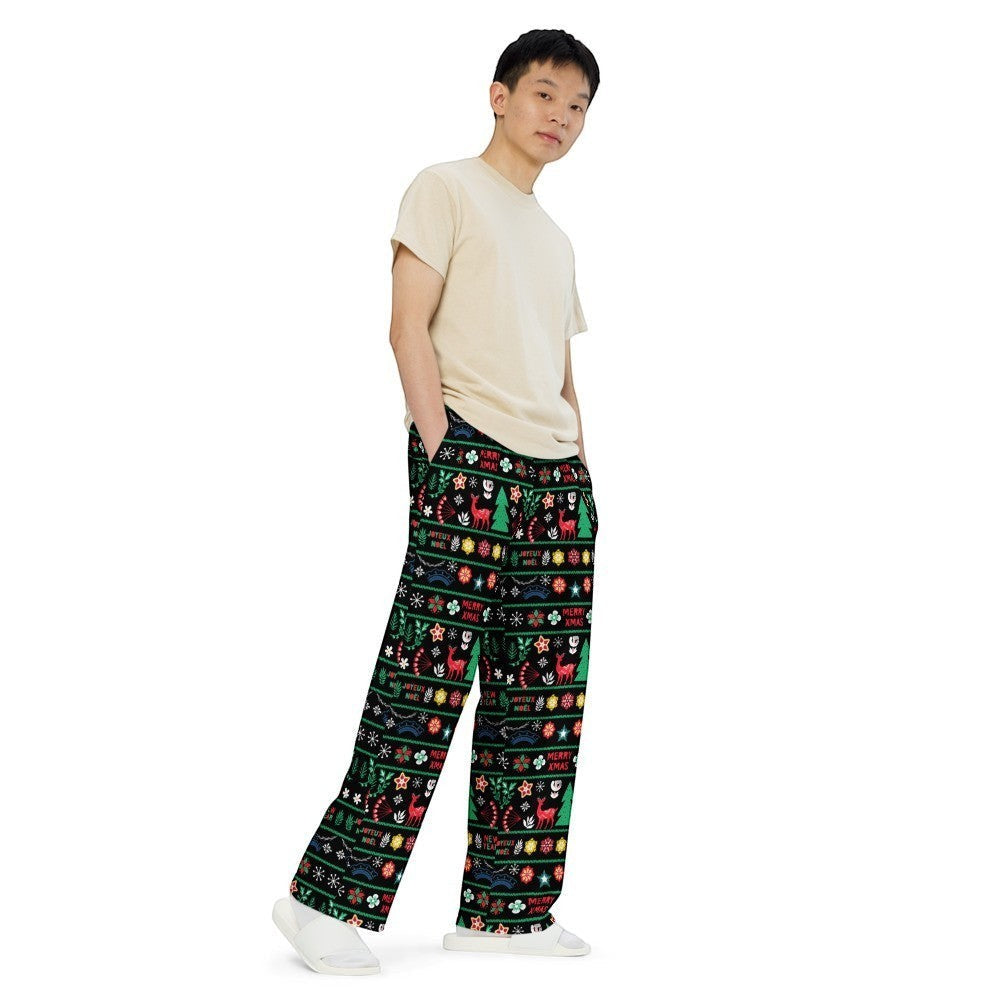 65mcmlxv unisex wide-leg lounge pants with black background and festive Nordic Christmas fairisle print. Features reindeer, trees, snowflakes, and text.