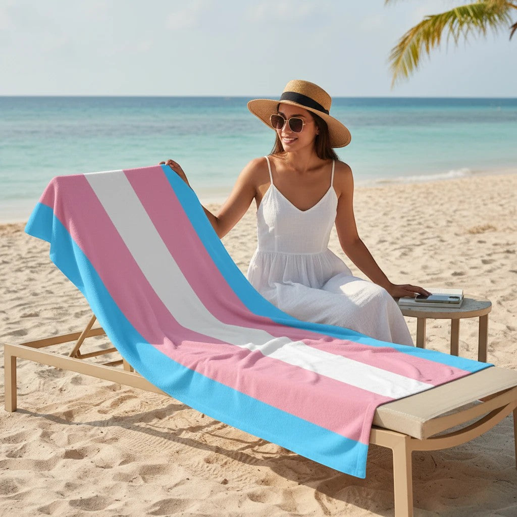65 MCMLXV transgender pride flag beach towel with pink, white, and blue stripes. Soft, absorbent, 50% polyester, 50% cotton.